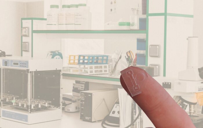 lab met op de voorgrond een vinger met mini-chip erop